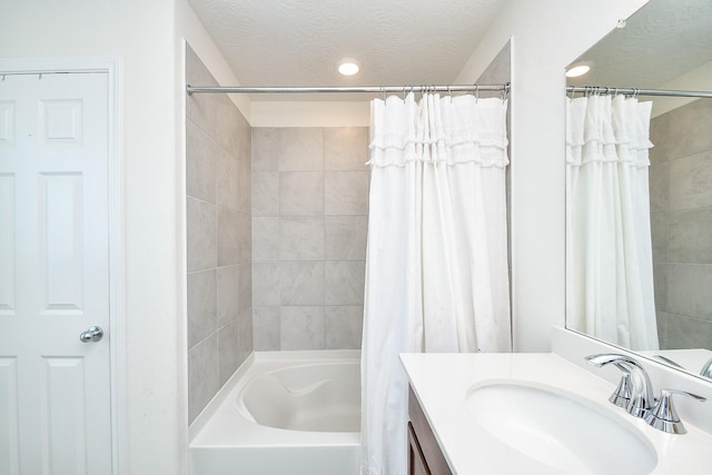 bathroom featuring shower / bath combo with shower curtain, vanity, and a textured ceiling