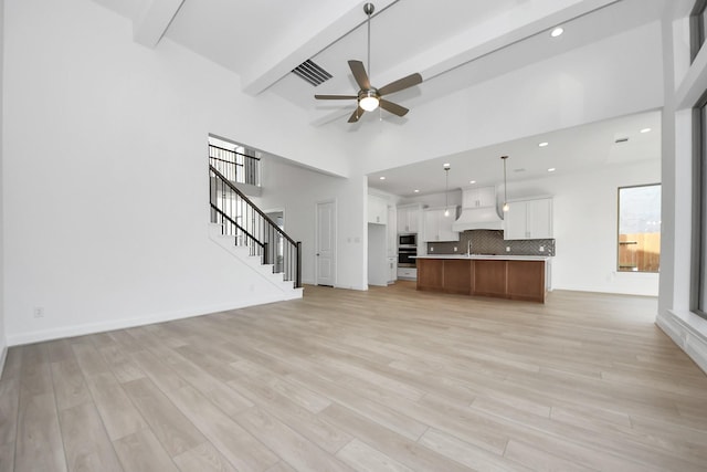 21123 Flowerhorn Dr, Cypress, TX 77433 - unfurnished living room featuring beamed ceiling, a ceiling fan, light wood-style flooring, stairway, and recessed lighting