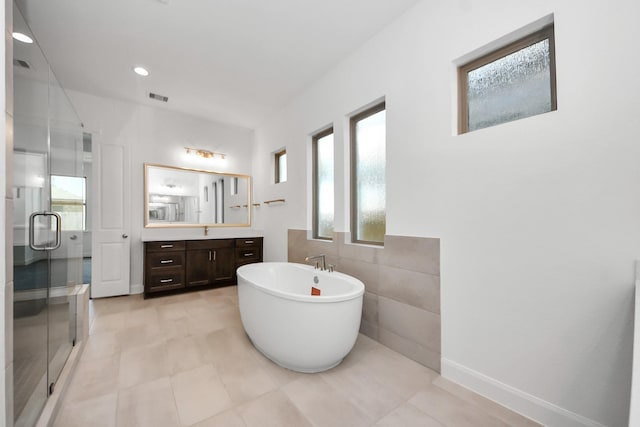 21123 Flowerhorn Dr, Cypress, TX 77433 - bathroom featuring vanity, a shower stall, a freestanding tub, and tile walls
