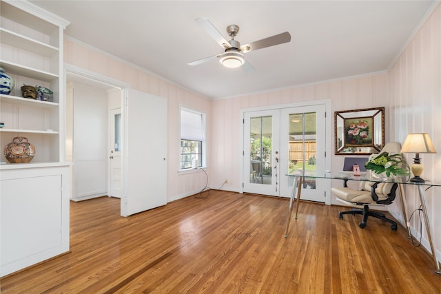 unfurnished office with crown molding, a ceiling fan, french doors, and light wood finished floors