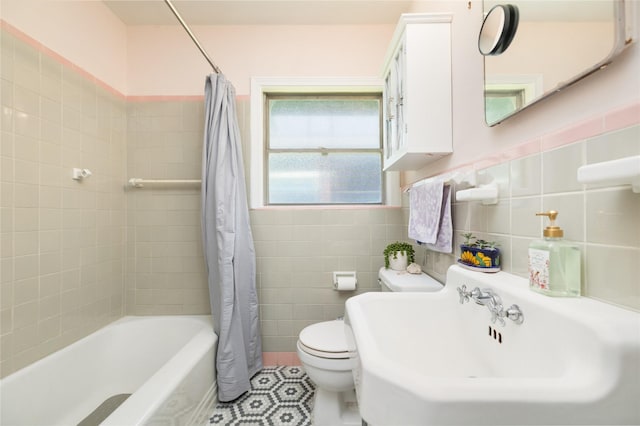full bath featuring tile patterned flooring, shower / bath combination with curtain, toilet, tile walls, and a sink