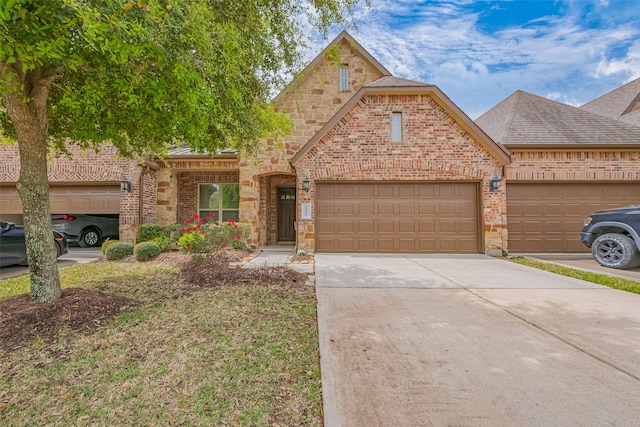 view of front of property with driveway, stone siding, an attached garage, brick siding, and a shingled roof