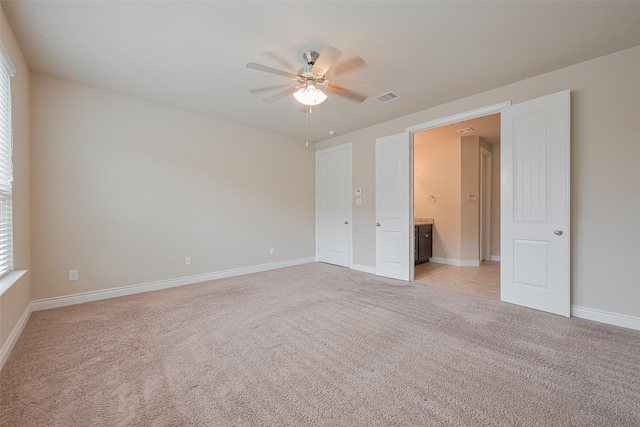 unfurnished bedroom with visible vents, baseboards, a ceiling fan, and light carpet