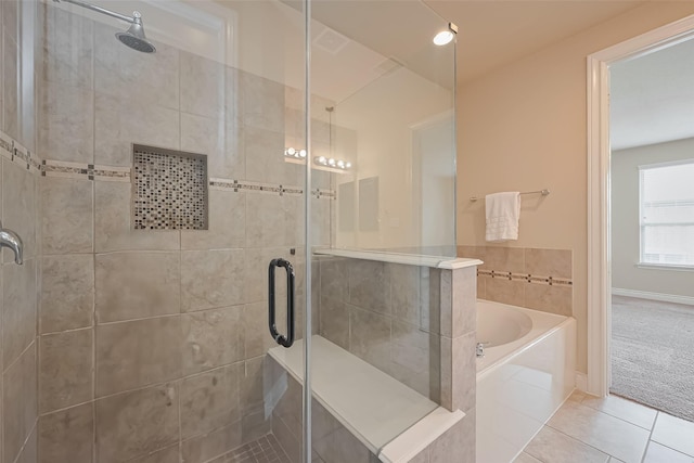 full bath featuring tile patterned floors, a bath, a stall shower, and baseboards