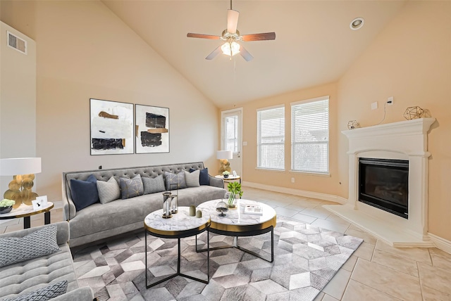 living room featuring high vaulted ceiling, ceiling fan, a glass covered fireplace, visible vents, and light tile patterned flooring