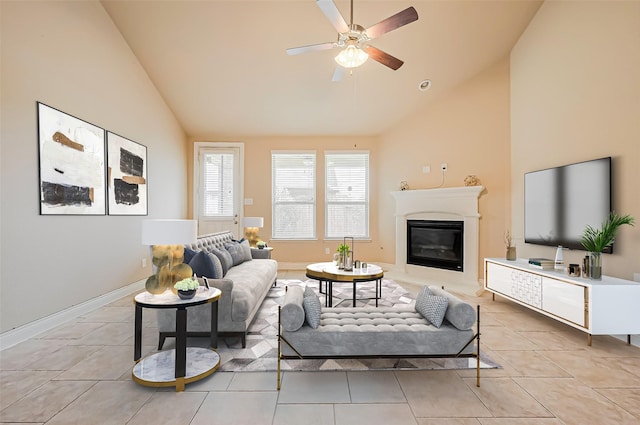living area with light tile patterned floors, high vaulted ceiling, a ceiling fan, and a glass covered fireplace