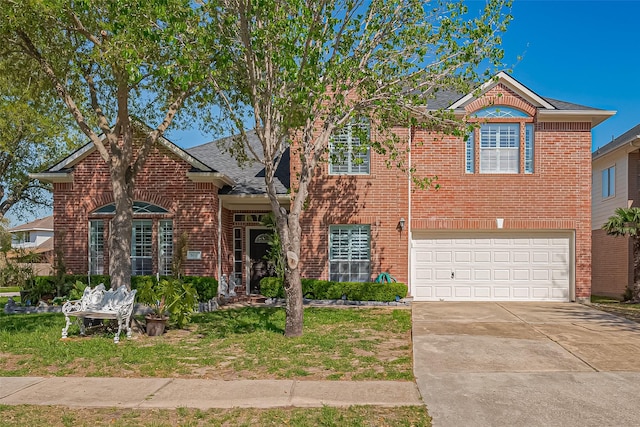 traditional home featuring a shingled roof, an attached garage, a front lawn, brick siding, and driveway
