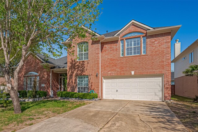 traditional home featuring a garage, concrete driveway, and brick siding