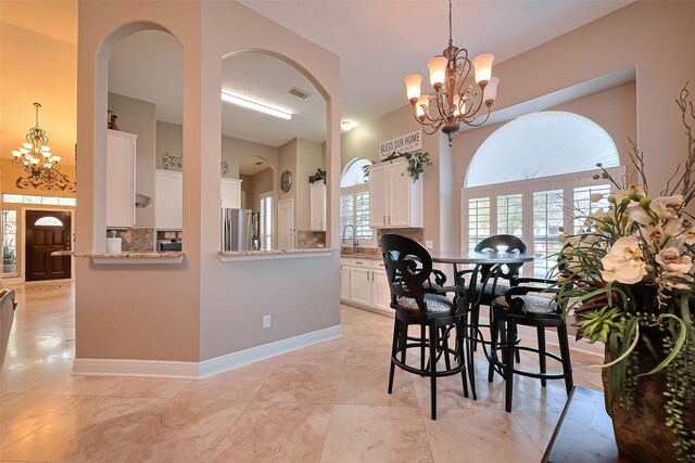 dining area featuring an inviting chandelier, arched walkways, and visible vents