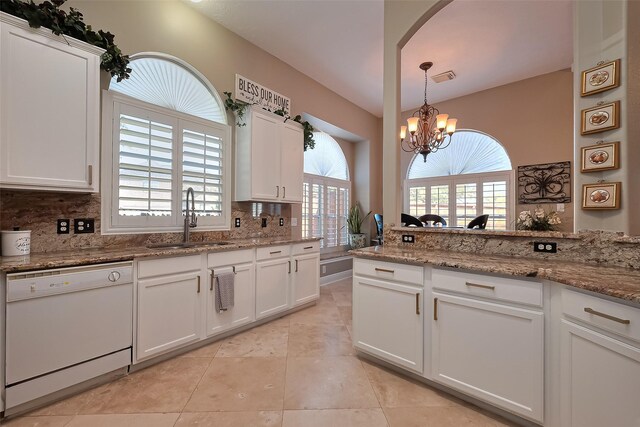 kitchen with decorative backsplash, white dishwasher, a sink, an inviting chandelier, and white cabinetry