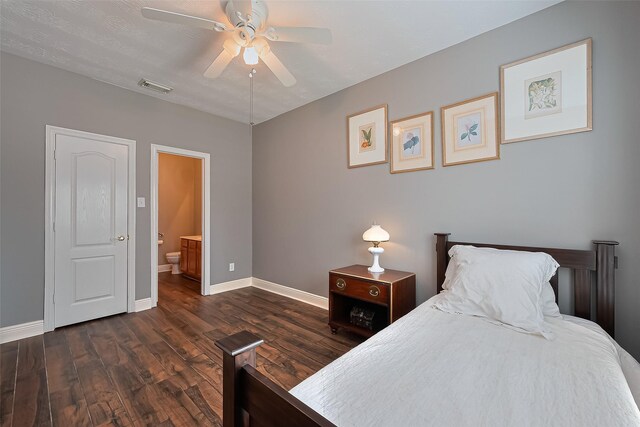 bedroom featuring a ceiling fan, dark wood-style flooring, visible vents, baseboards, and ensuite bathroom