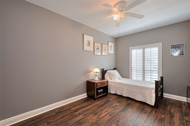 bedroom featuring baseboards, a ceiling fan, and dark wood-style flooring