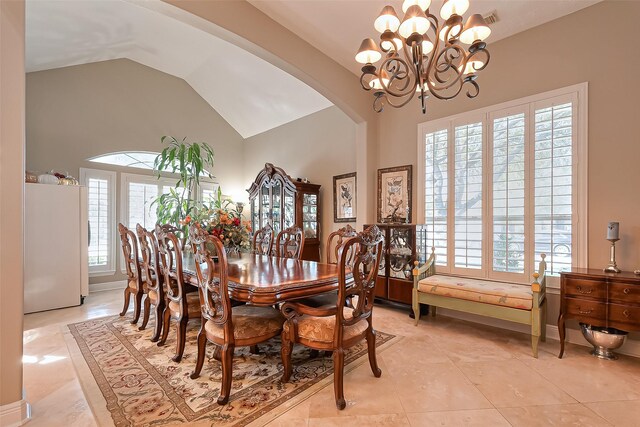 dining area with arched walkways, a chandelier, plenty of natural light, and light tile patterned floors