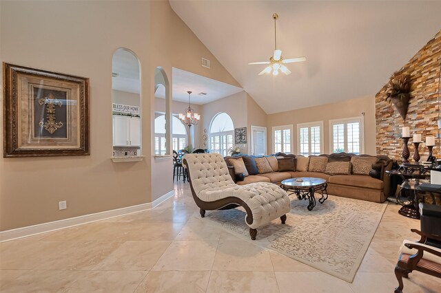 living area featuring arched walkways, high vaulted ceiling, ceiling fan with notable chandelier, baseboards, and visible vents