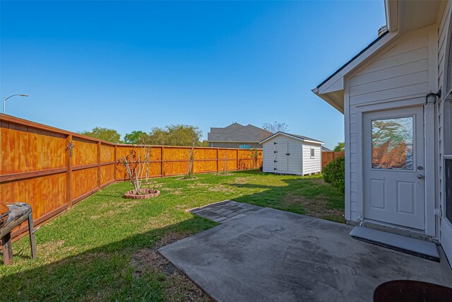 view of yard with a fenced backyard, a patio area, a storage shed, and an outbuilding