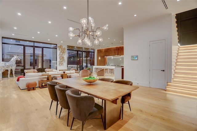 1810 Dunlavy St, Houston, TX 77006 - dining area featuring light wood-style flooring, stairs, recessed lighting, a wall of windows, and a chandelier