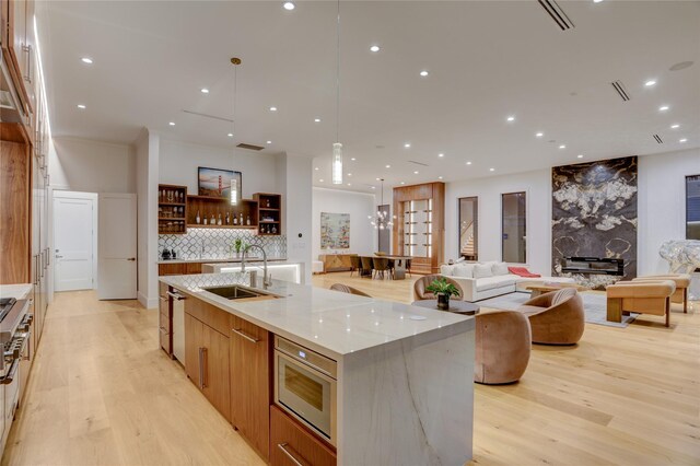 1810 Dunlavy St, Houston, TX 77006 - kitchen featuring a sink, modern cabinets, light wood-style floors, open floor plan, and a large island with sink