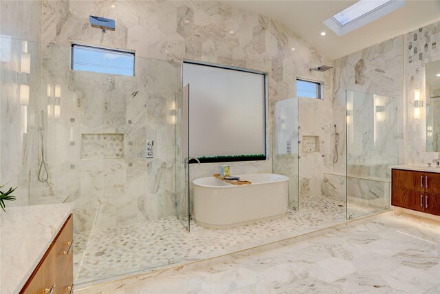 1810 Dunlavy St, Houston, TX 77006 - full bathroom with vanity, a skylight, a marble finish shower, tile walls, and a freestanding tub