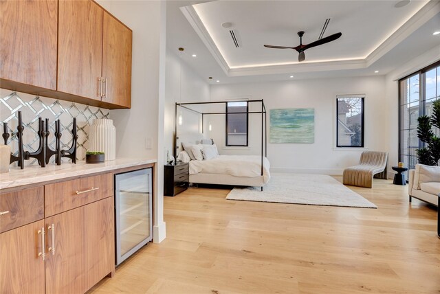 1810 Dunlavy St, Houston, TX 77006 - bedroom featuring wine cooler, a tray ceiling, light wood-style flooring, and bar