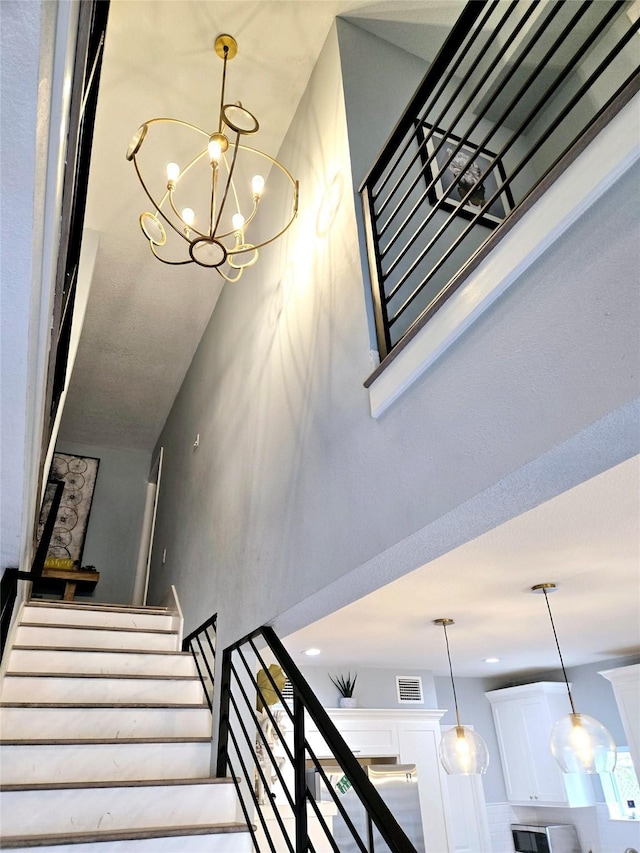 stairs featuring a chandelier
