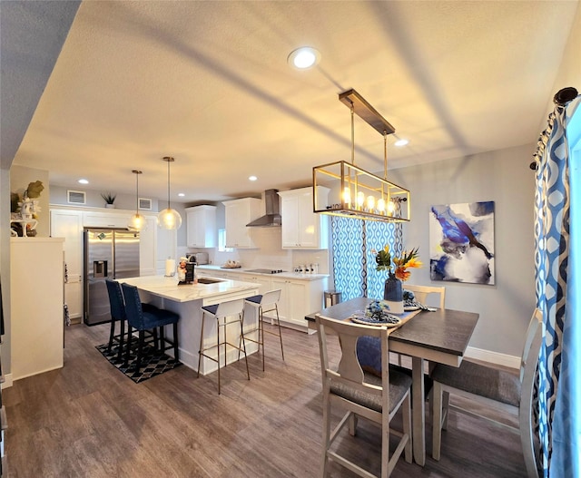 dining area featuring dark wood-style floors, recessed lighting, baseboards, and a chandelier