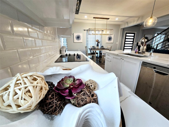kitchen featuring a sink, dishwasher, black electric cooktop, white cabinets, and pendant lighting