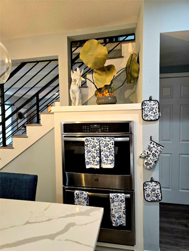 detailed view of double wall oven and wood finished floors
