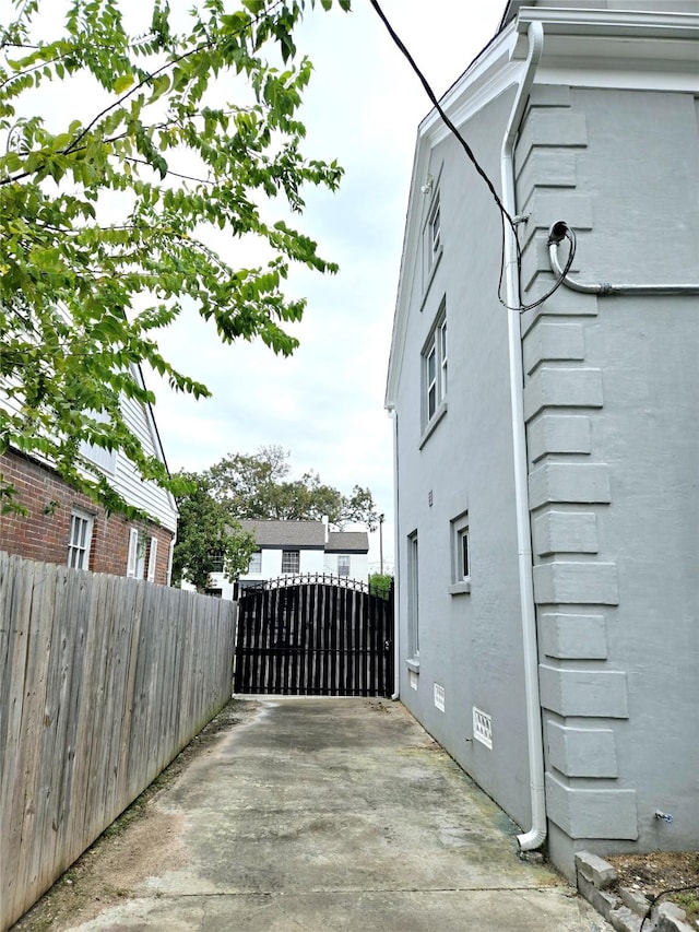 view of property exterior featuring fence and a gate