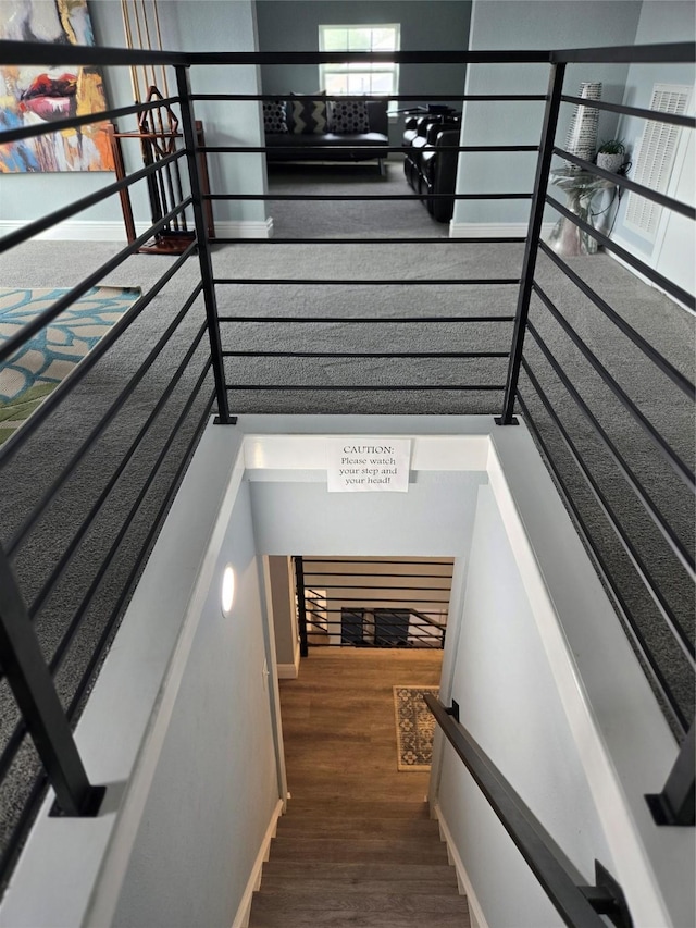 stairway with wood finished floors and baseboards