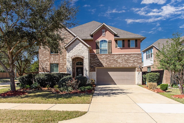 view of front of property featuring an attached garage, driveway, stone siding, and stucco siding