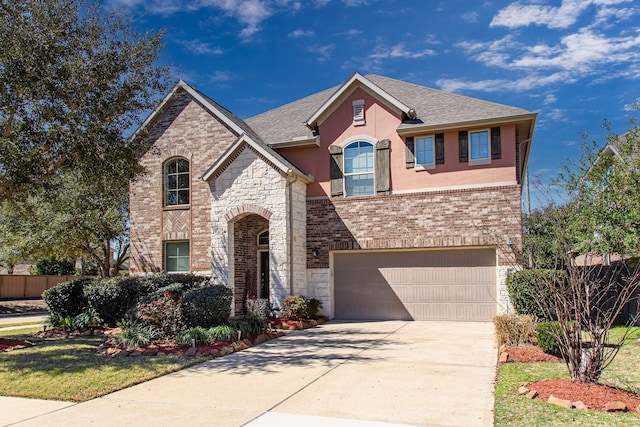view of front facade featuring an attached garage, driveway, stone siding, stucco siding, and brick siding