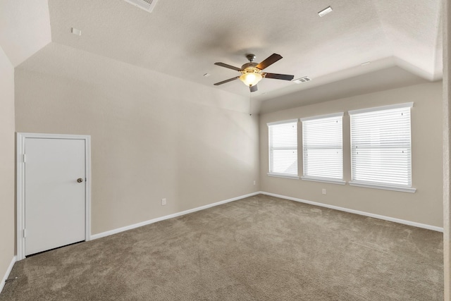 carpeted empty room featuring ceiling fan, baseboards, a textured ceiling, and vaulted ceiling