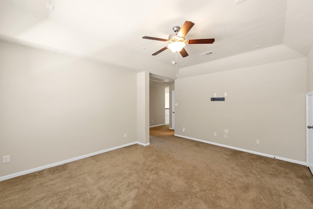 carpeted spare room with a ceiling fan and baseboards