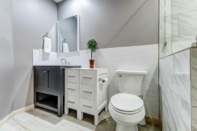 bathroom with tile walls, toilet, and vanity