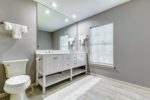 bathroom featuring a sink, baseboards, and wood finished floors