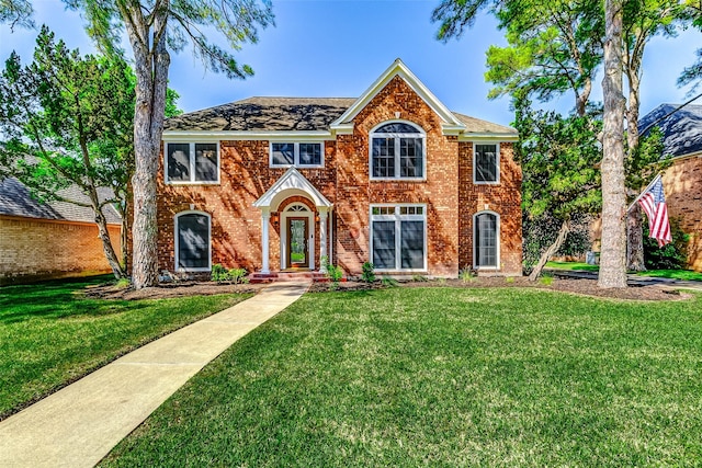 view of front of property featuring a front yard and brick siding
