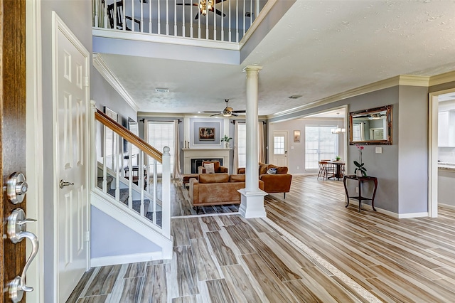 entrance foyer with ornamental molding, baseboards, ornate columns, and a wealth of natural light