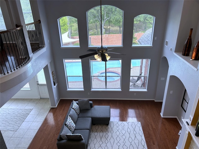 11603 Shoal Landing St, Pearland, TX 77584 - living area featuring a ceiling fan, wood finished floors, plenty of natural light, a towering ceiling, and baseboards