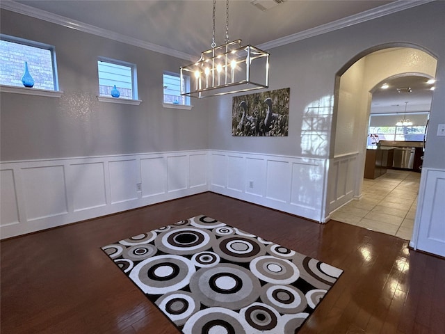 11603 Shoal Landing St, Pearland, TX 77584 - unfurnished dining area featuring a chandelier, wood finished floors, plenty of natural light, a decorative wall, and crown molding
