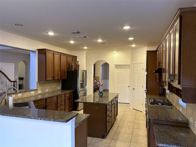 11603 Shoal Landing St, Pearland, TX 77584 - kitchen with arched walkways, stainless steel appliances, a center island, backsplash, and recessed lighting