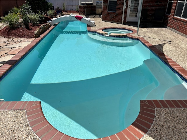 11603 Shoal Landing St, Pearland, TX 77584 - view of swimming pool featuring a patio, a pool with connected hot tub, and central AC