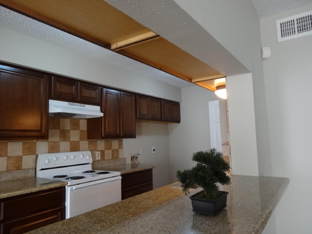 kitchen featuring white electric stove, tasteful backsplash, under cabinet range hood, visible vents, and dark brown cabinets