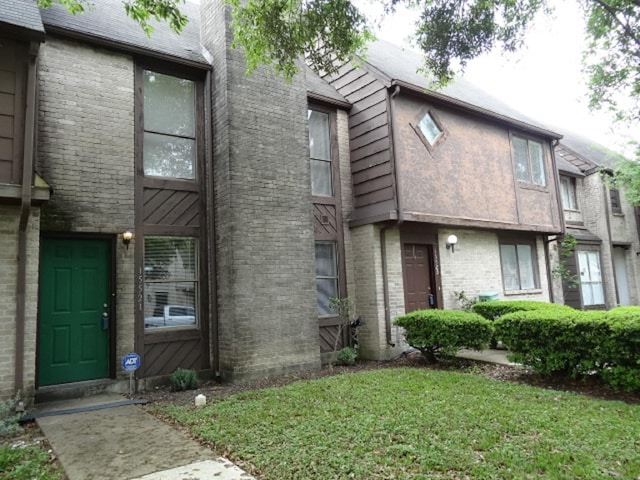exterior space featuring a front yard and brick siding