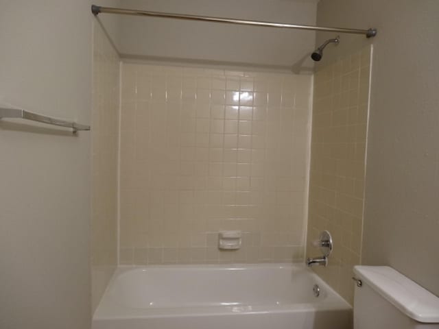 bathroom with toilet and bathing tub / shower combination