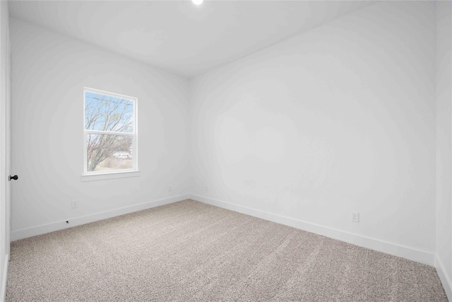 spare room featuring carpet floors and baseboards