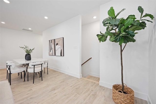 dining room featuring baseboards, light wood finished floors, and recessed lighting