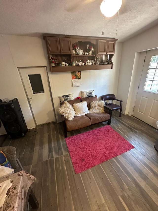 living area with hardwood / wood-style flooring and a textured ceiling
