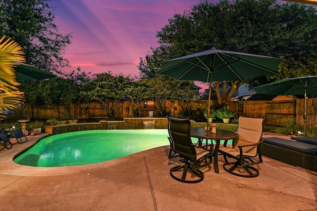 view of swimming pool with a fenced backyard, a fenced in pool, outdoor dining area, and a patio area