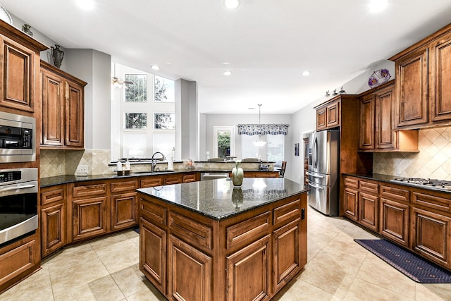 kitchen featuring a kitchen island, a sink, tasteful backsplash, and appliances with stainless steel finishes