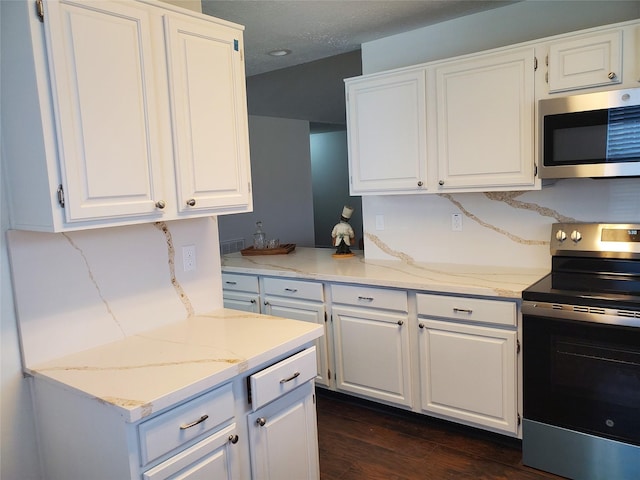 13002 Nantucket Dr, Sugar Land, TX 77478 - kitchen with white cabinets, light stone countertops, appliances with stainless steel finishes, and dark wood-style floors